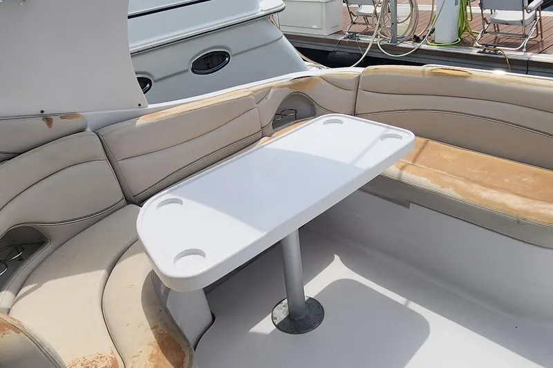 Slide: The Image of 2006 Larson 3700 Cabrio boat interior with seating and table, docked at marina. - 7