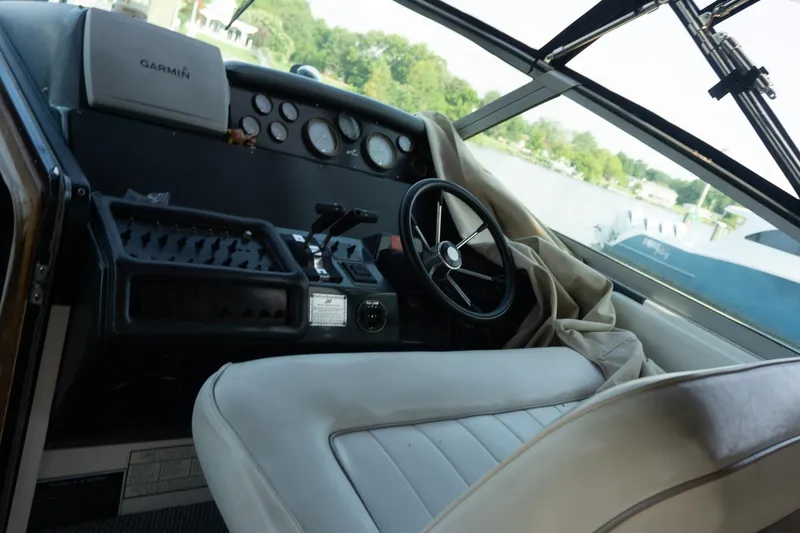 Slide: The Image of Cockpit of 1993 Sea Ray 400 Express Cruiser with steering wheel and navigation equipment. - 12