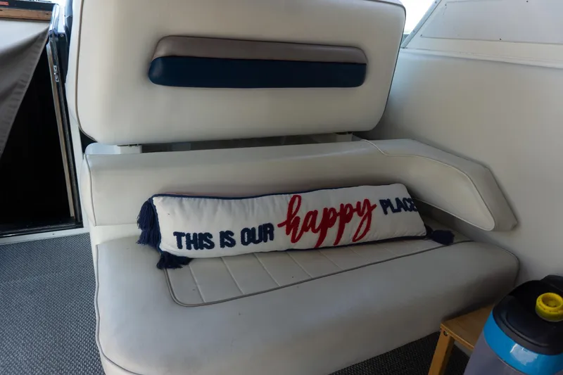 Slide: The Image of 1993 Sea Ray 400 Express Cruiser interior with "This is our happy place" pillow on white seat. - 17