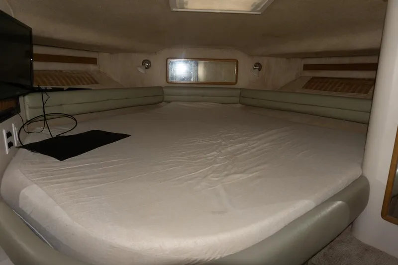 Slide: The Image of 1993 Sea Ray 400 Express Cruiser cabin with spacious bed and modern amenities. - 26
