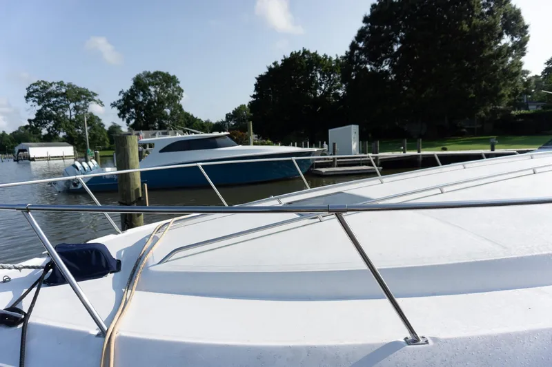 Slide: The Image of 1993 Sea Ray 400 Express Cruiser docked near a marina, with trees in the background. - 8