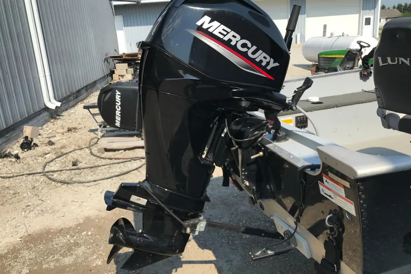 Slide: The Image of 2013 Lund 1600 Fury Tiller boat with Mercury outboard motor, parked outdoors. - 14