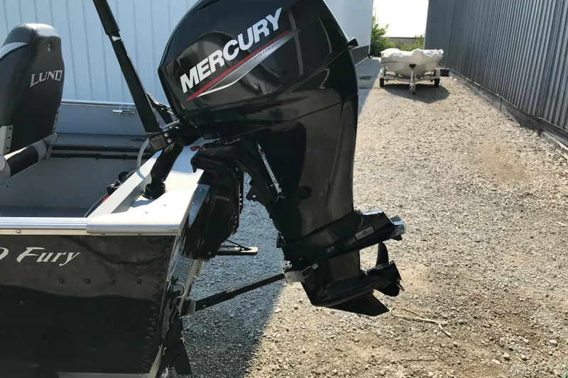 Slide: The Image of 2013 Lund 1600 Fury Tiller boat with Mercury outboard motor on gravel path. - 15