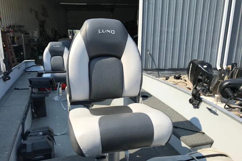Slide: The Image of 2013 Lund 1600 Fury Tiller boat interior with cushioned seats and motor. - 18