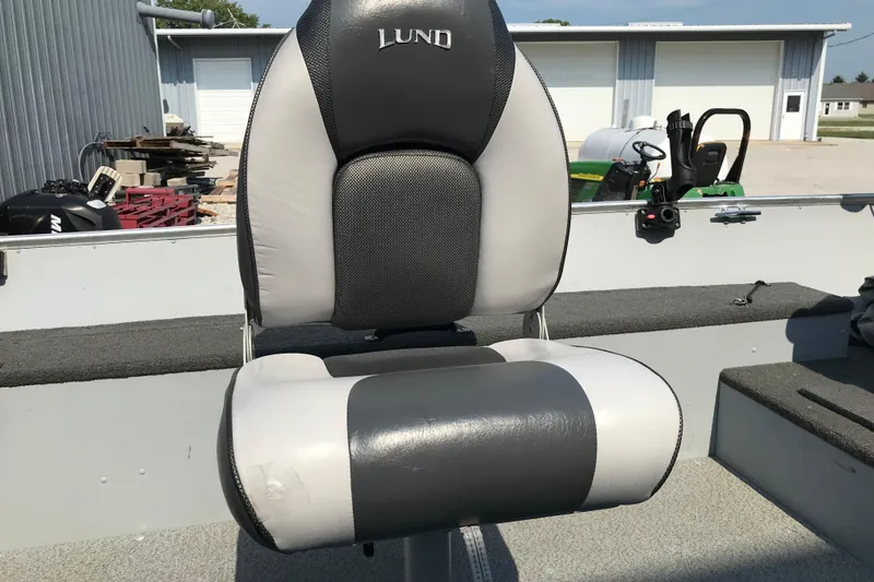 Slide: The Image of Lund 1600 Fury Tiller 2013 boat seat, gray and black, in outdoor setting. - 19