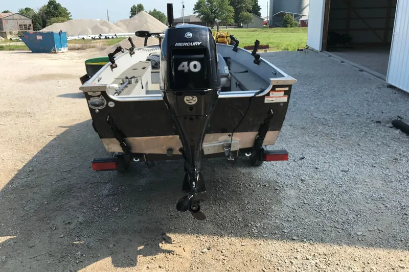 Slide: The Image of 2013 Lund 1600 Fury Tiller boat with Mercury 40 outboard motor, parked on gravel. - 5
