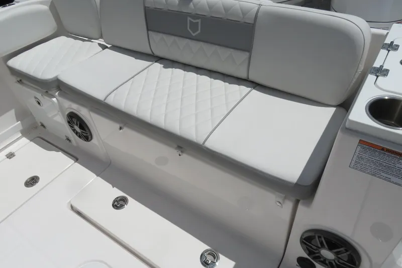 Slide: The Image of White cushioned seating on 2025 Sea Fox 268 Commander boat, featuring speakers and cup holder. - 26