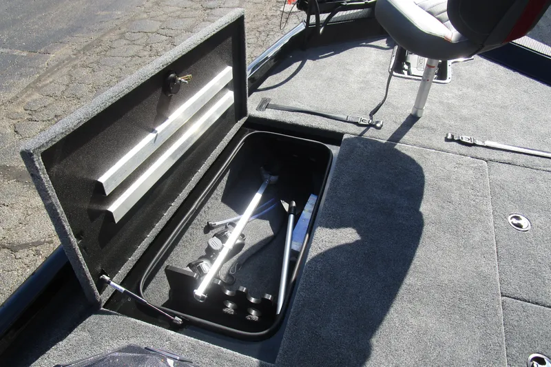 Slide: The Image of 2025 Ranger RT 198 P boat storage compartment with open lid and fishing rod holders. - 12