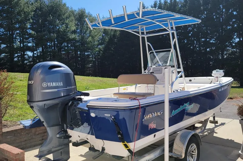 Slide: The Image of 2022 Sundance 20DX boat with Yamaha engine on trailer, parked outdoors. - 1