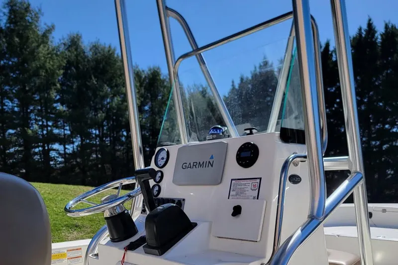 Slide: The Image of 2022 Sundance 20DX boat console with Garmin navigation, surrounded by trees. - 4