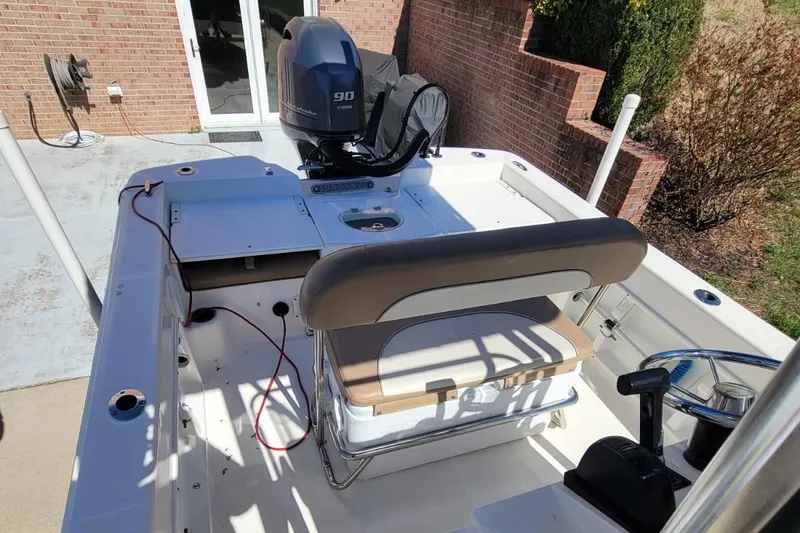 Slide: The Image of 2022 Sundance 20DX boat with Yamaha 90 engine, parked near brick wall. - 8