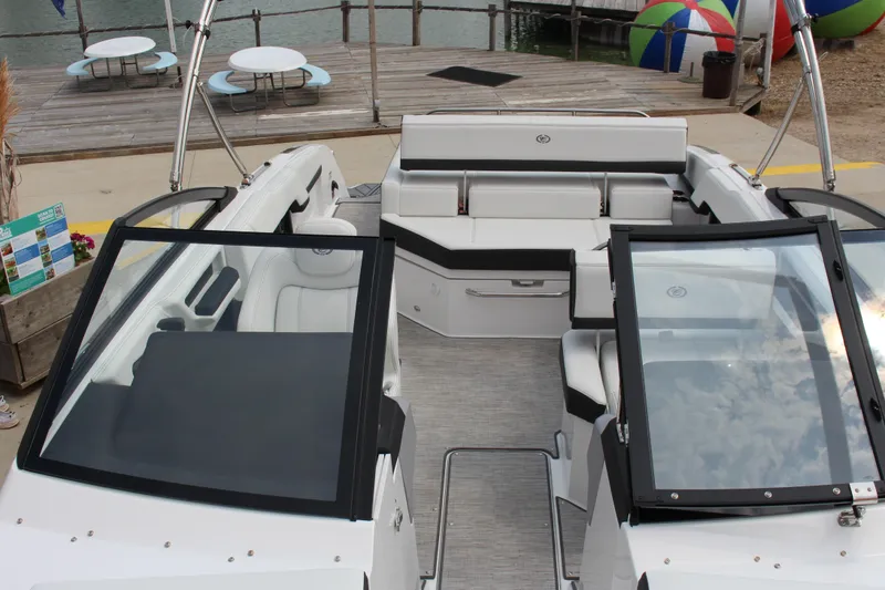 Slide: The Image of 2025 Cobalt R4 Surf boat interior with sleek seating and modern design at a dock. - 24