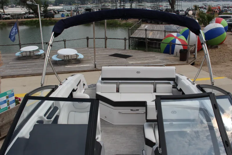 Slide: The Image of 2025 Cobalt R4 Surf boat interior at a lakeside dock with colorful beach balls. - 25