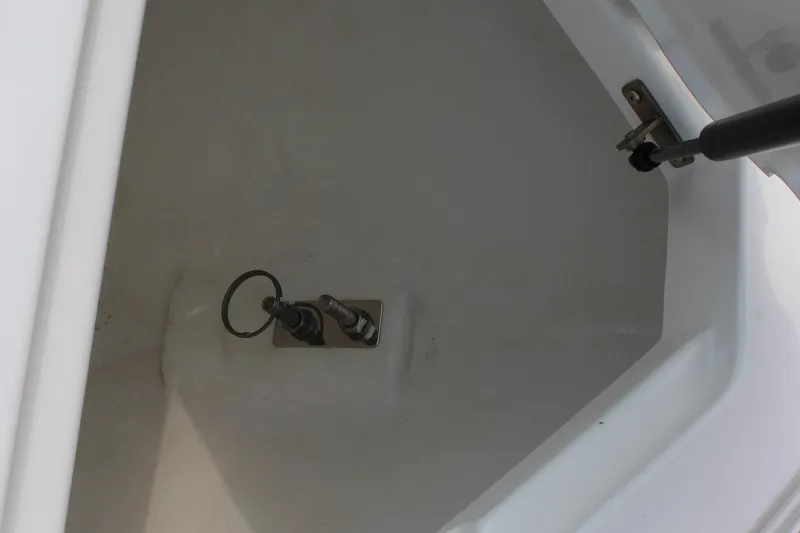 Slide: The Image of Open storage compartment in 2025 Cobalt R4 Surf boat, featuring metal latch and hydraulic support. - 28