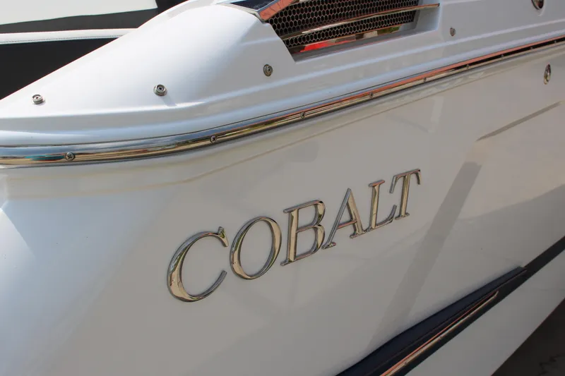 Slide: The Image of 2025 Cobalt R4 Surf boat, close-up of sleek white exterior with logo. - 7