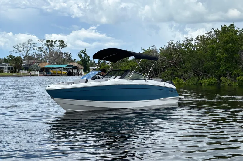 Slide: The Image of 2026 Cobalt R4 Outboard boat on calm water, surrounded by lush greenery. - 3