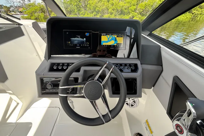 Slide: The Image of 2026 Cobalt R4 Outboard boat dashboard with steering wheel and navigation screens. - 9