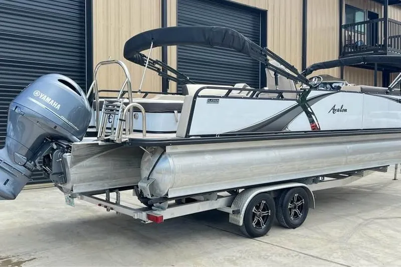 Slide: The Image of 2024 Avalon LSV 2585 pontoon boat on trailer with Yamaha outboard motor. - 2