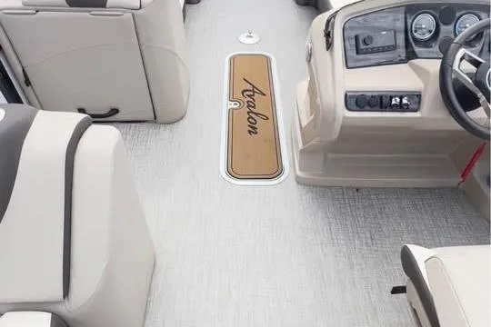 Slide: The Image of 2024 Avalon LSV 2585 boat interior with beige seating and modern dashboard. - 7