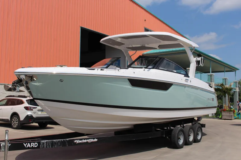 The Image of 2025 Cobalt R31 Surf boat on trailer, parked near an orange building. - 0