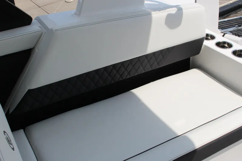 Slide: The Image of 2025 Cobalt R31 Surf boat interior with white and black cushioned seating. - 13