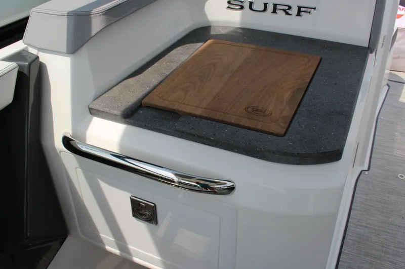 Slide: The Image of 2025 Cobalt R31 Surf boat interior with cutting board and storage compartment. - 25