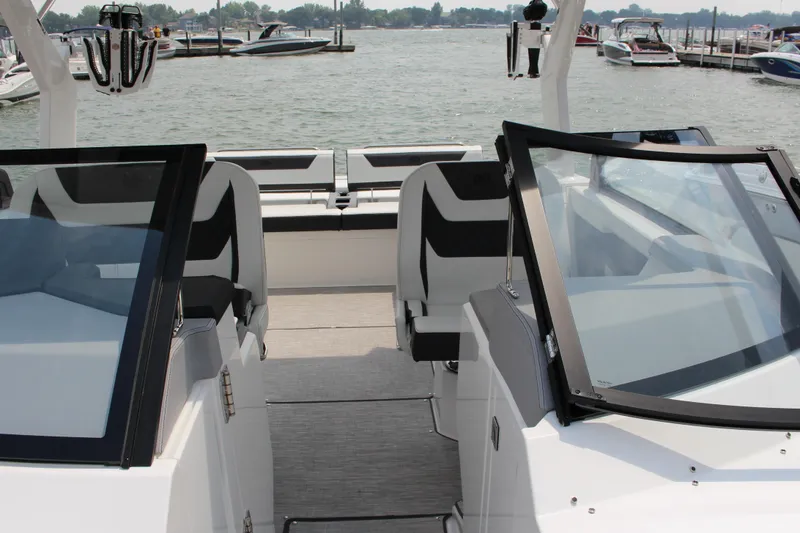Slide: The Image of 2025 Cobalt R31 Surf boat interior with sleek seating and modern design at a marina. - 26