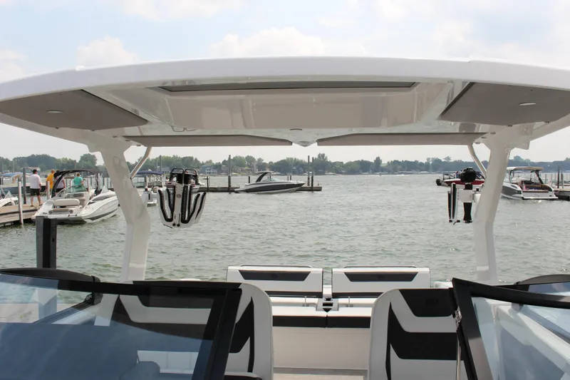 Slide: The Image of 2025 Cobalt R31 Surf boat docked at a marina, showcasing sleek design and spacious seating. - 27