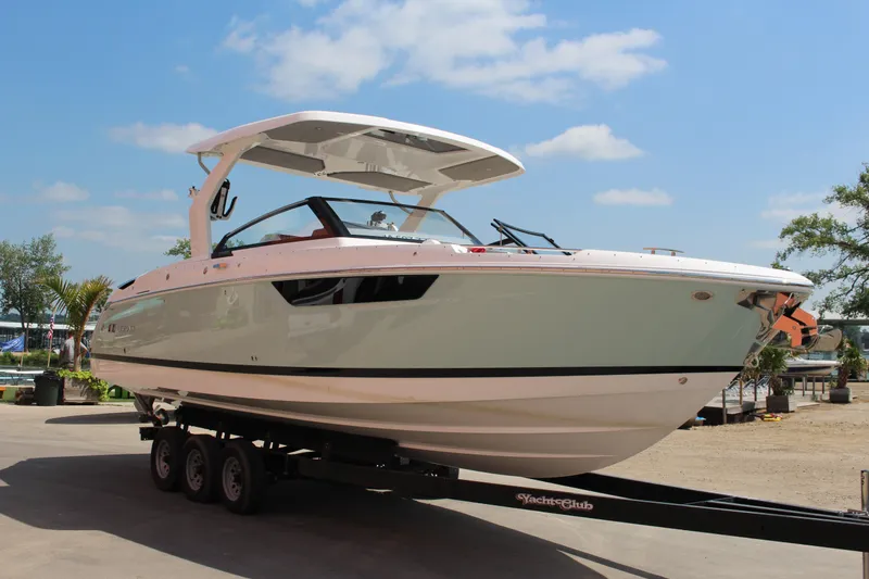 Slide: The Image of 2025 Cobalt R31 Surf boat on trailer under clear blue sky. - 41