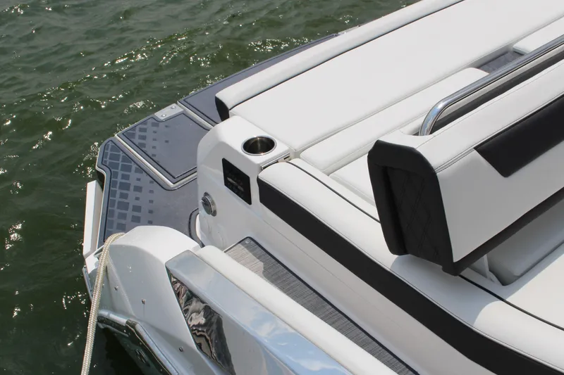 Slide: The Image of 2025 Cobalt R31 Surf boat's sleek rear deck and seating on water. - 6