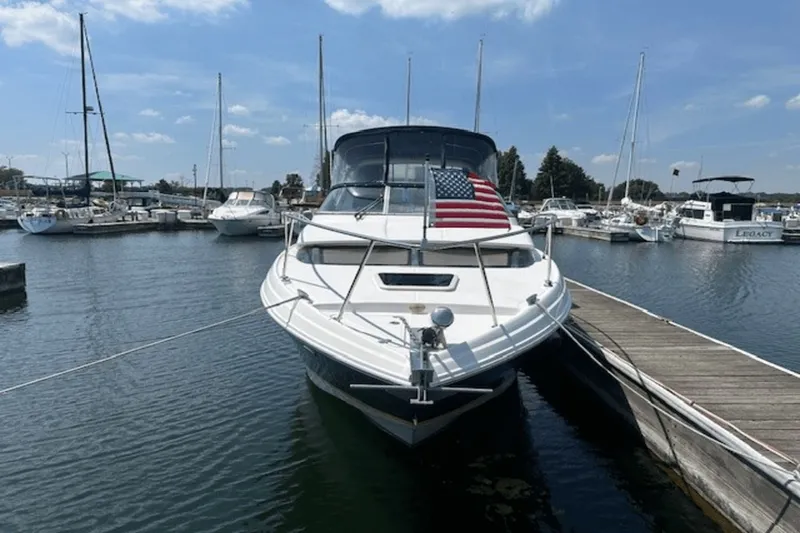 Slide: The Image of 2008 Regal 2860 Window Express boat docked with American flag, surrounded by other boats. - 2