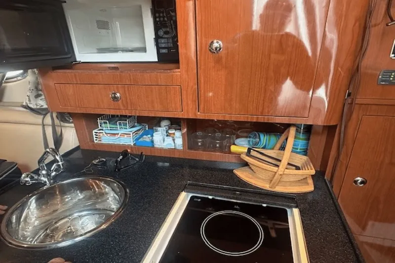 Slide: The Image of 2008 Regal 2860 Window Express kitchen with microwave, sink, and wooden cabinetry. - 33