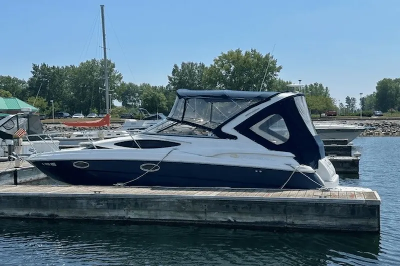 Slide: The Image of 2008 Regal 2860 Window Express boat docked at marina, featuring sleek design and blue canopy. - 4