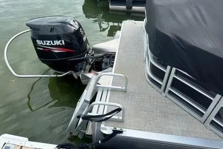 Slide: The Image of 2017 Berkshire 22CL CTS pontoon boat with Suzuki outboard motor, docked on calm water. - 4