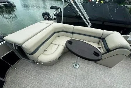 Slide: The Image of 2017 Berkshire 22CL CTS pontoon boat with beige seating and round table on a lake. - 9
