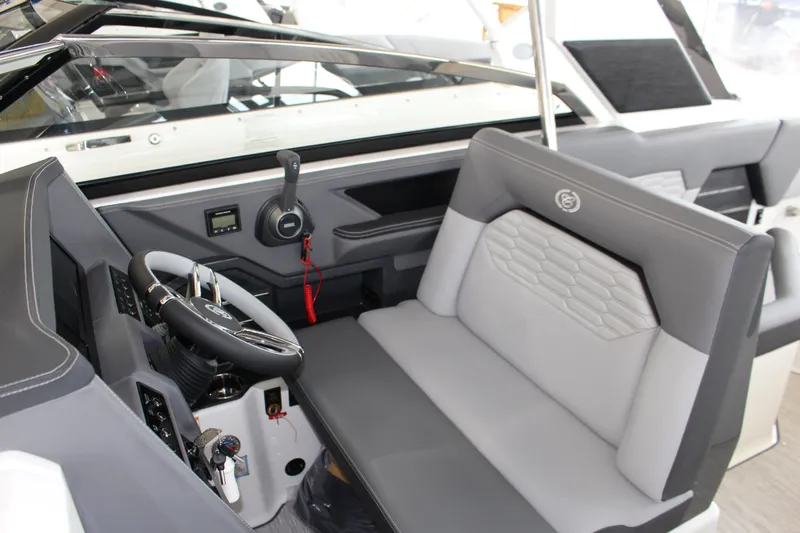 Slide: The Image of 2025 Cobalt A29 boat interior with sleek gray seating and modern steering console. - 2
