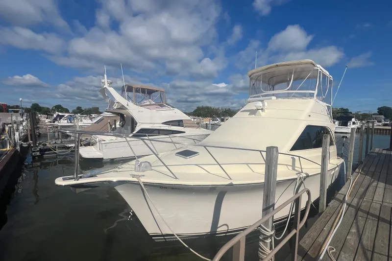 Slide: The Image of 1990 Ocean Yachts 35 Sport Sedan docked at marina under blue sky. - 1
