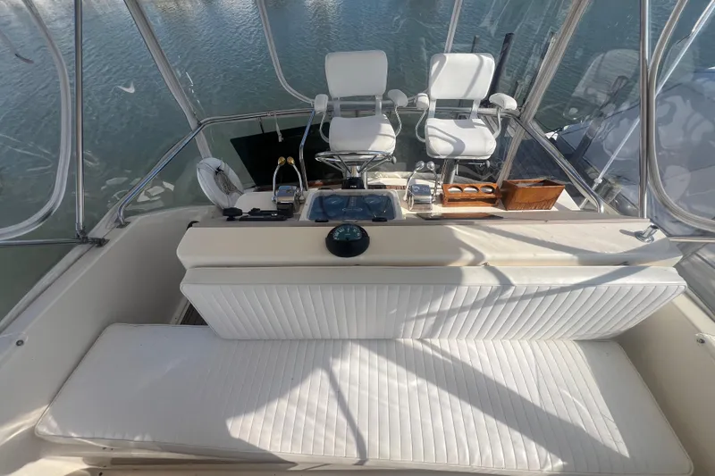 Slide: The Image of 1990 Ocean Yachts 35 Sport Sedan cockpit with white seating and helm controls. - 10