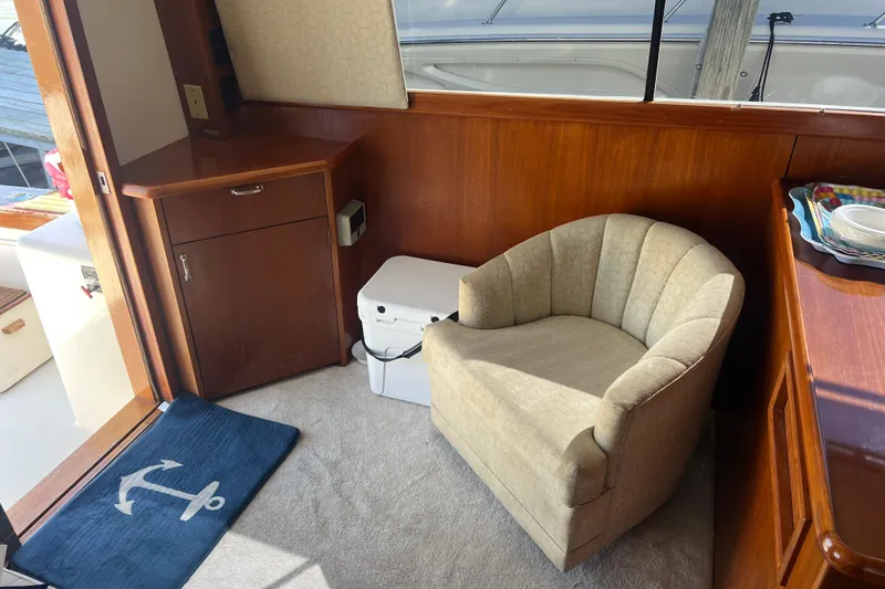 Slide: The Image of Interior of 1990 Ocean Yachts 35 Sport Sedan with chair and wooden cabinetry. - 12