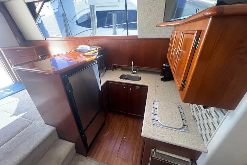 Slide: The Image of 1990 Ocean Yachts 35 Sport Sedan kitchen with wood cabinetry and compact appliances. - 15