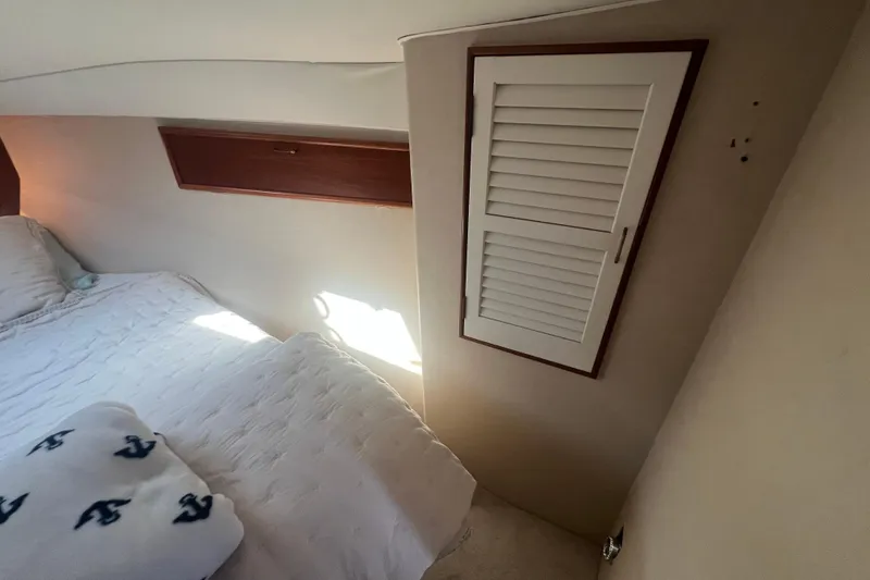 Slide: The Image of Cozy cabin interior of 1990 Ocean Yachts 35 Sport Sedan with bed and storage. - 21