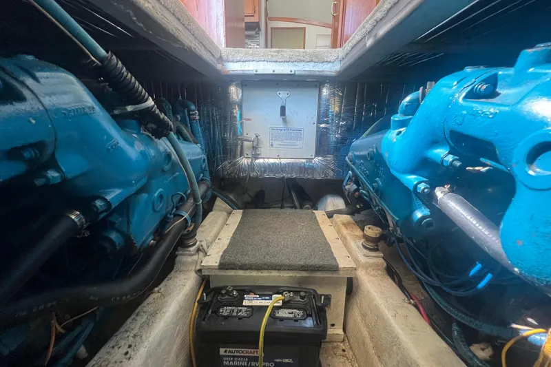 Slide: The Image of Engine room of 1990 Ocean Yachts 35 Sport Sedan with visible blue engines and battery. - 22