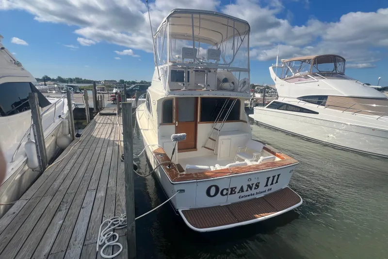 Slide: The Image of 1990 Ocean Yachts 35 Sport Sedan docked at marina under blue sky. - 3