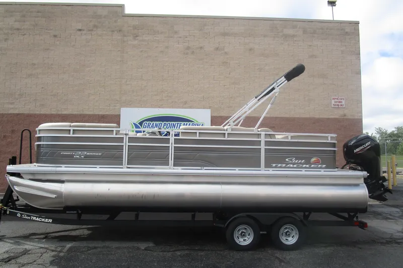 The Image of 2025 Sun Tracker PB 22 RF pontoon boat on trailer, parked outdoors. - 1