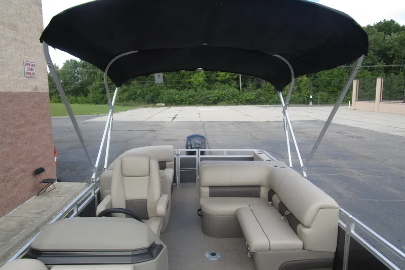 Slide: The Image of 2025 Sun Tracker PB 22 RF pontoon boat with beige seating and black canopy. - 19