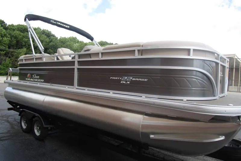 Slide: The Image of 2025 Sun Tracker PB 22 RF pontoon boat on trailer, parked outdoors. - 4