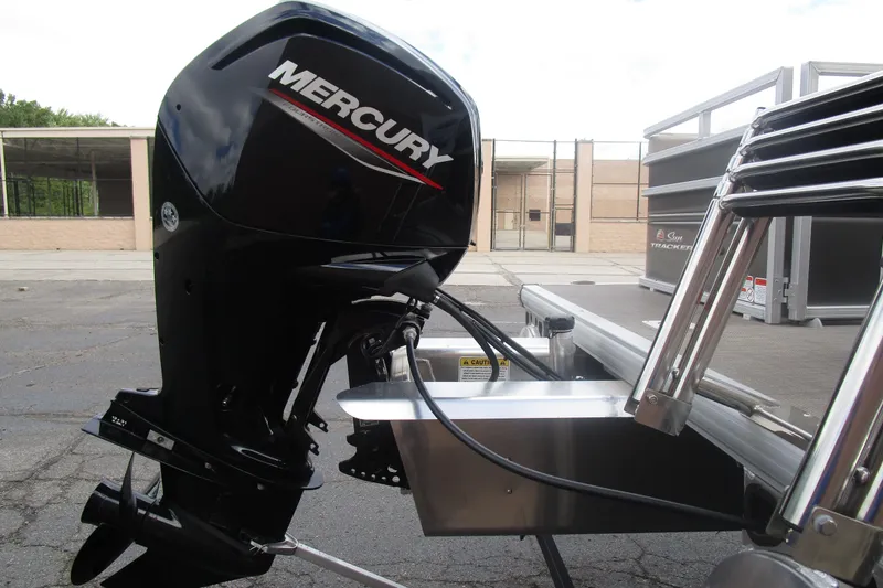 Slide: The Image of 2025 Sun Tracker PB 22 RF with Mercury outboard motor, parked outdoors. - 6