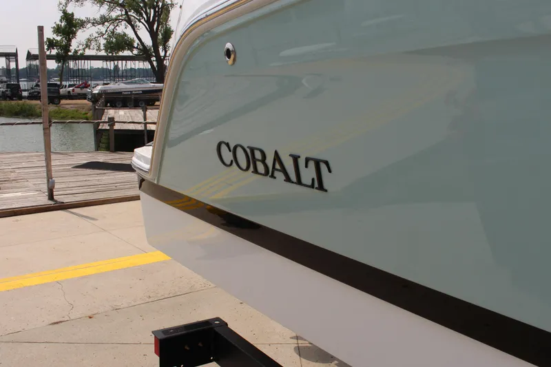 Slide: The Image of 2025 Cobalt CS23 boat docked near a marina, showcasing sleek design. - 11