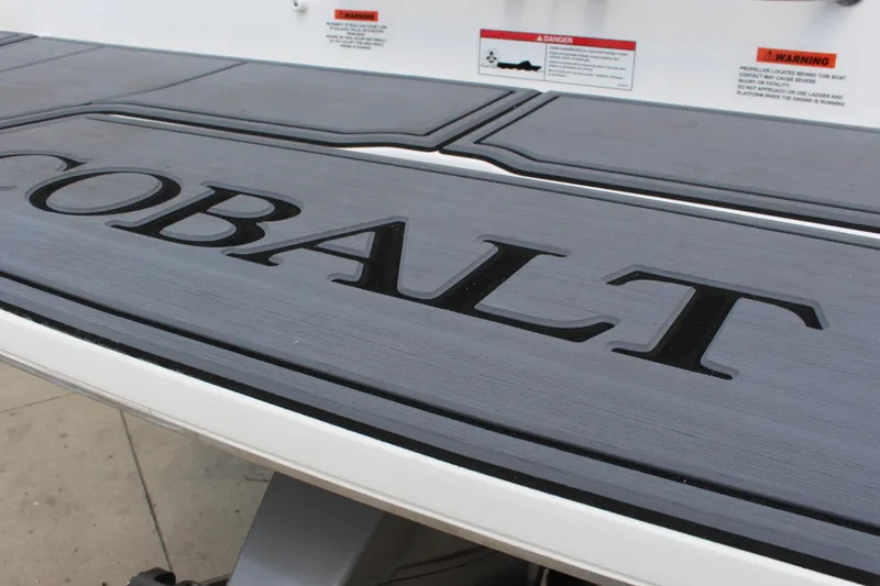 Slide: The Image of 2025 Cobalt CS23 boat deck with engraved logo and safety warnings. - 16