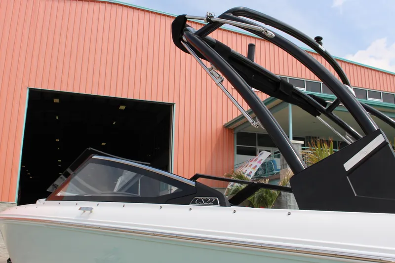 Slide: The Image of 2025 Cobalt CS23 boat near a large orange warehouse, showcasing sleek design. - 18